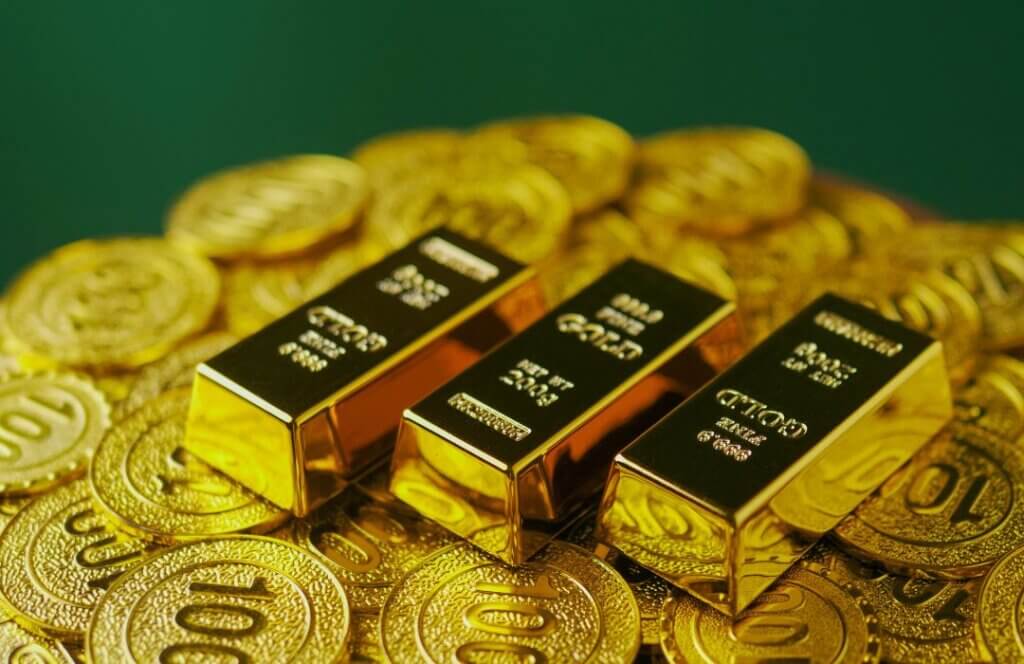 Stacked 999.9 fine gold bars on gold coins symbolizing long-term wealth preservation, financial security, and inflation protection