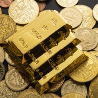 Gold bars on coins illustrating a gold tax haven and the hidden wealth advantage of tax-free gold