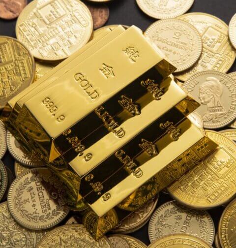 Gold bars on coins illustrating a gold tax haven and the hidden wealth advantage of tax-free gold