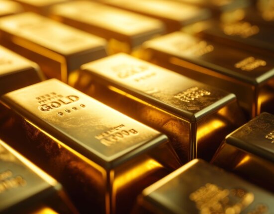 Close-up of stacked gold bars with engraved fine gold markings, symbolizing global gold reserves, limited supply, peak gold, and rising gold prices in 2026